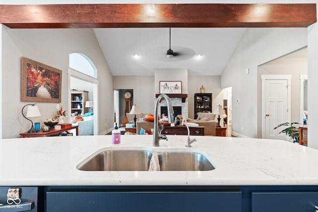 kitchen featuring blue cabinetry, ceiling fan, sink, and lofted ceiling