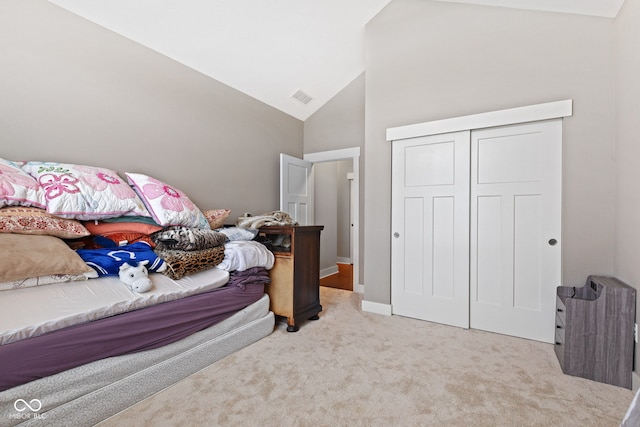 bedroom with light carpet, a closet, and vaulted ceiling