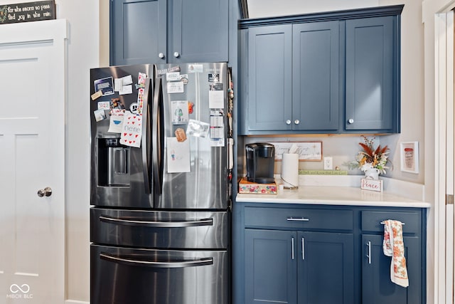 kitchen with blue cabinetry and stainless steel refrigerator with ice dispenser