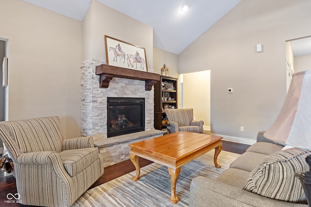 living room with a stone fireplace, wood-type flooring, and vaulted ceiling