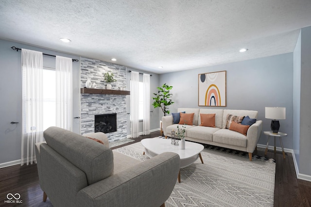 living room with a textured ceiling, a stone fireplace, and hardwood / wood-style flooring