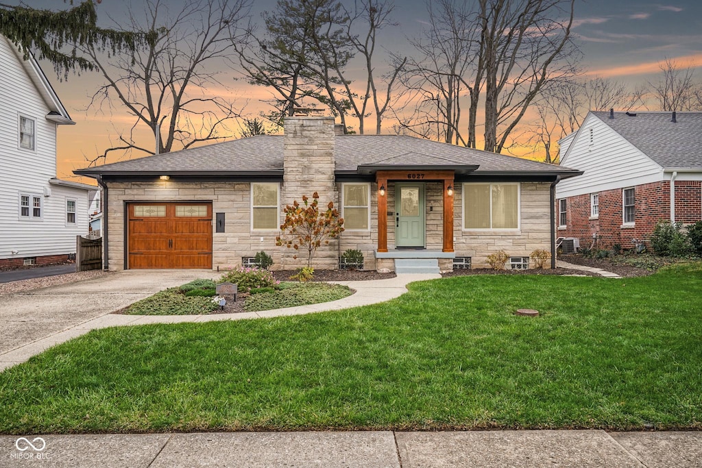 view of front facade with a lawn and a garage