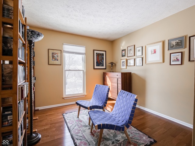 living area featuring a textured ceiling and dark hardwood / wood-style floors