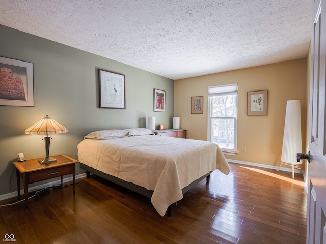 bedroom featuring dark wood-type flooring and a textured ceiling