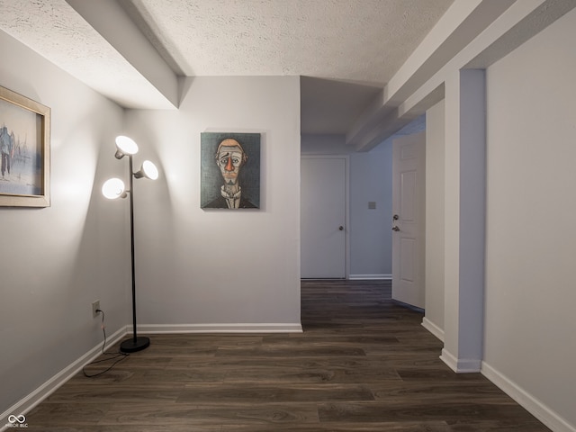 hall with a textured ceiling and dark hardwood / wood-style floors