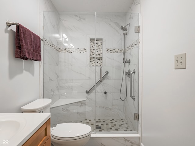 bathroom featuring vanity, toilet, and a shower with shower door