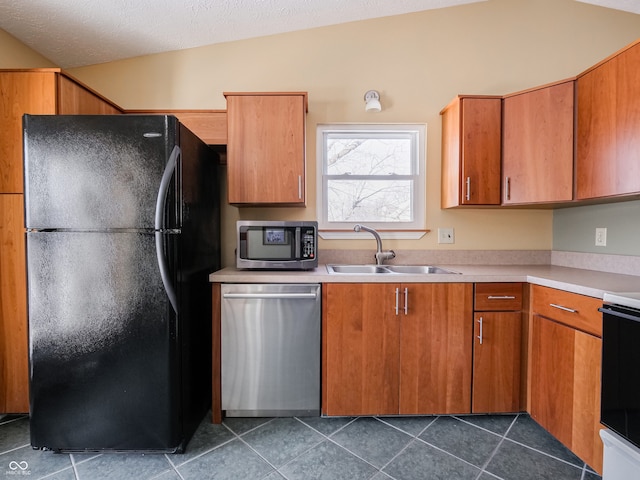 kitchen featuring lofted ceiling, sink, a textured ceiling, and appliances with stainless steel finishes