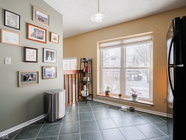 miscellaneous room with a textured ceiling and dark tile patterned flooring