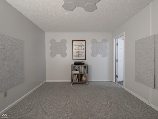 unfurnished room with carpet and a textured ceiling