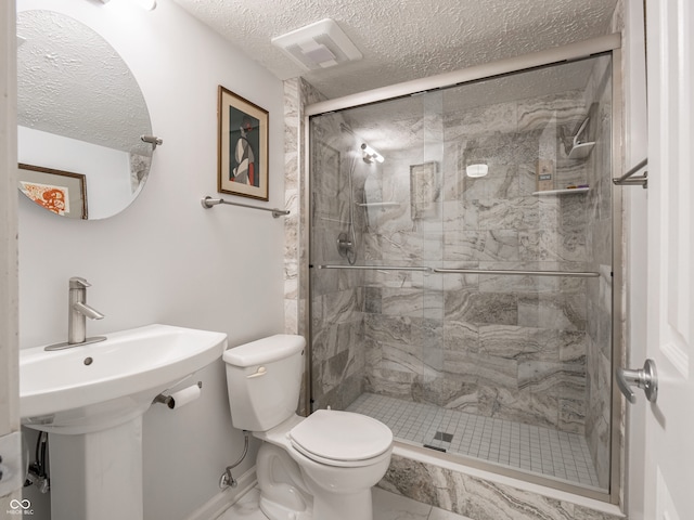 bathroom featuring a textured ceiling, toilet, and walk in shower