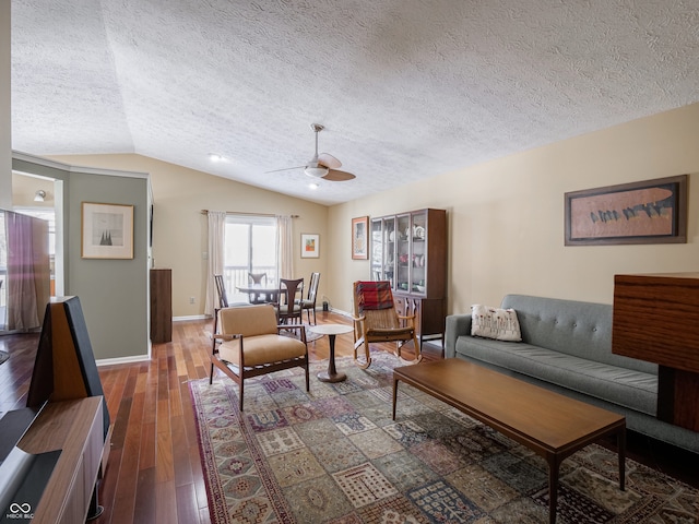 living room with a textured ceiling, ceiling fan, dark hardwood / wood-style flooring, and vaulted ceiling