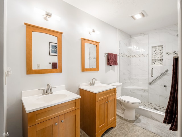 bathroom featuring two vanities, visible vents, a marble finish shower, and a sink