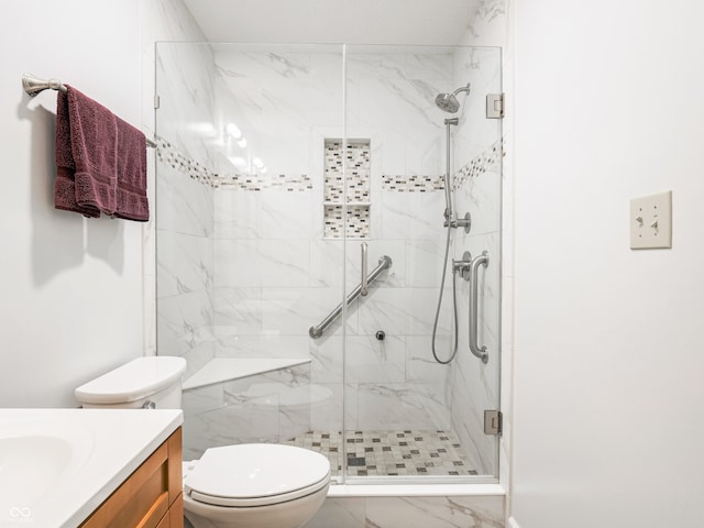 bathroom featuring a marble finish shower, toilet, and vanity