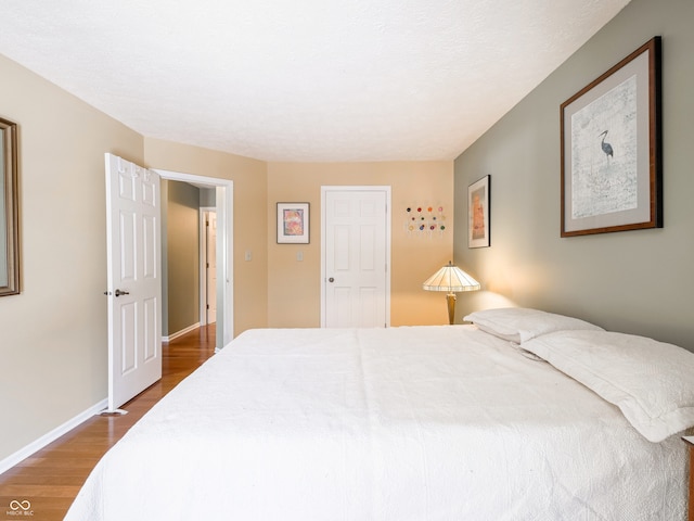 bedroom featuring wood finished floors and baseboards