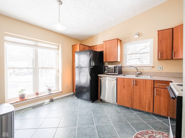 kitchen with a sink, light countertops, plenty of natural light, and stainless steel appliances