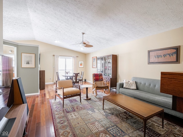 living room featuring baseboards, lofted ceiling, ceiling fan, hardwood / wood-style flooring, and a textured ceiling