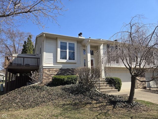 view of front of home featuring a garage, brick siding, concrete driveway, and a balcony