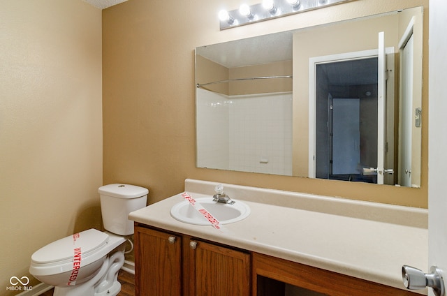 bathroom featuring walk in shower, vanity, and toilet