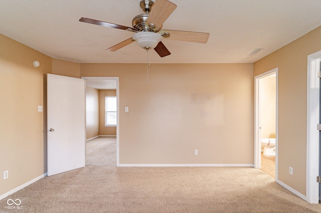 empty room featuring ceiling fan and light carpet