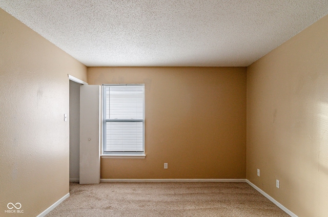 carpeted spare room with a textured ceiling