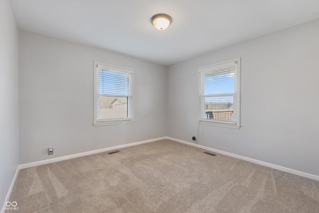 carpeted empty room featuring plenty of natural light