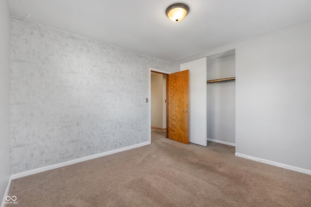 unfurnished bedroom with a closet and carpet floors