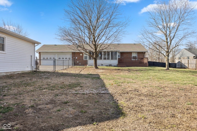 view of front of house featuring a wooden deck, a sunroom, a front yard, and a garage