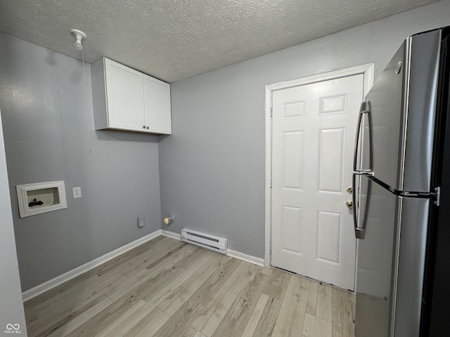 laundry room with cabinets, hookup for a washing machine, light wood-type flooring, a textured ceiling, and a baseboard radiator