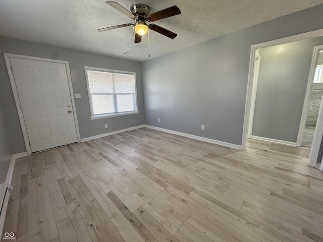 foyer entrance featuring a textured ceiling, a baseboard radiator, light hardwood / wood-style flooring, and ceiling fan