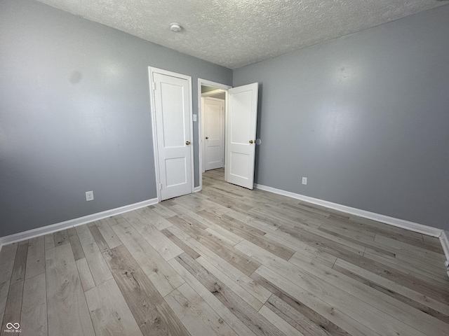 unfurnished bedroom featuring a textured ceiling and light wood-type flooring