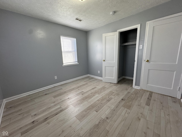 unfurnished bedroom featuring light hardwood / wood-style floors and a textured ceiling