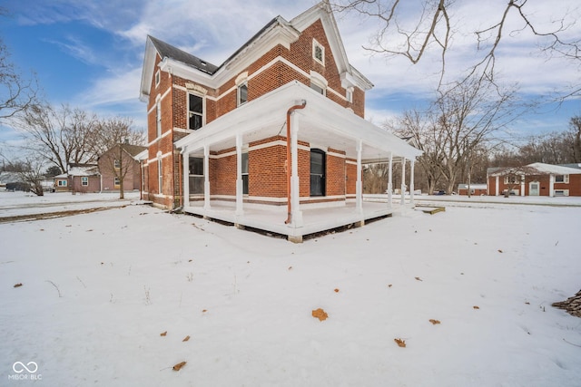 view of snow covered rear of property