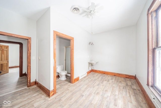 interior space featuring ceiling fan, a baseboard radiator, and light wood-type flooring