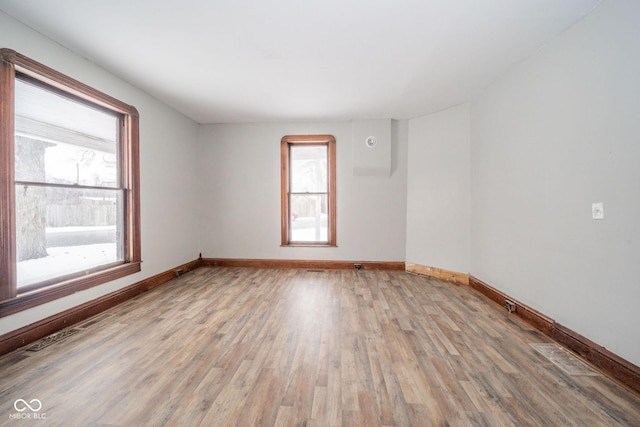 empty room featuring light wood-type flooring and a healthy amount of sunlight