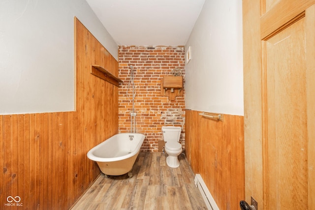 bathroom featuring a bath, a baseboard radiator, toilet, and hardwood / wood-style floors