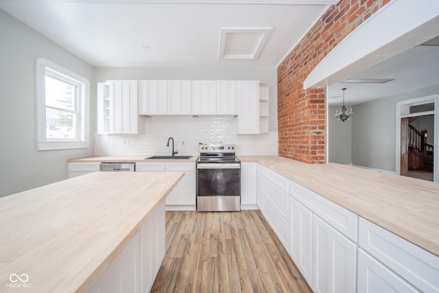 kitchen with white cabinetry, sink, appliances with stainless steel finishes, and an inviting chandelier