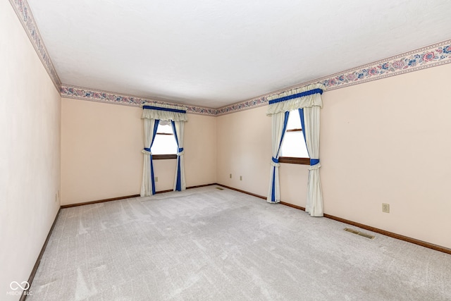 empty room featuring a wealth of natural light and carpet