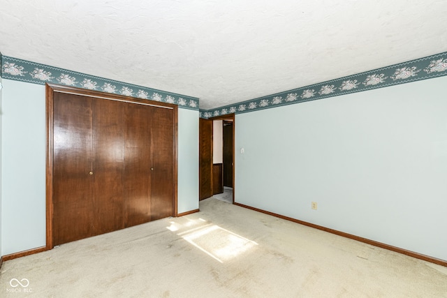 unfurnished bedroom with carpet floors, a textured ceiling, and a closet