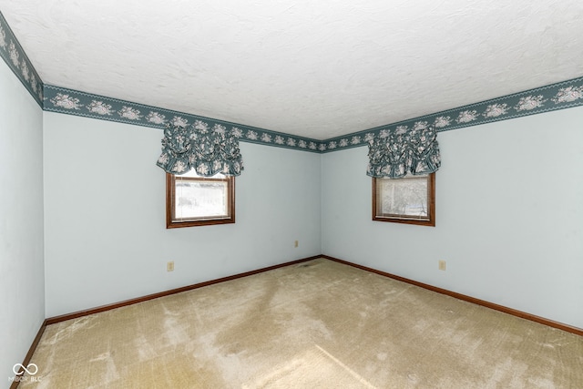 spare room featuring a textured ceiling and carpet floors