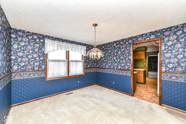 carpeted empty room with a textured ceiling