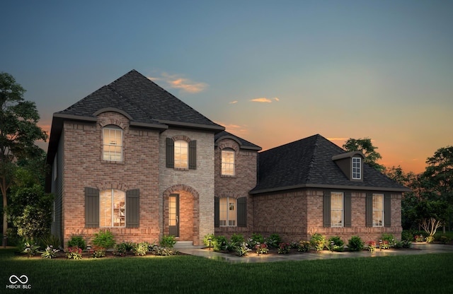 french country inspired facade featuring a lawn