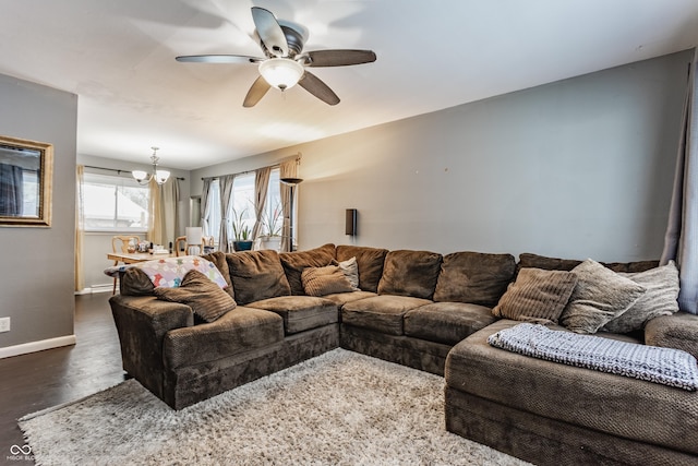 living room featuring dark hardwood / wood-style floors and ceiling fan with notable chandelier