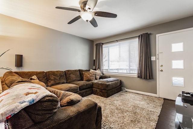 living room featuring ceiling fan and dark wood-type flooring