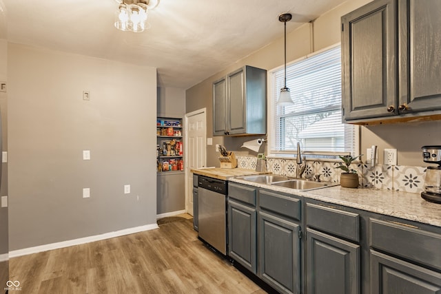 kitchen featuring gray cabinetry, sink, decorative light fixtures, dishwasher, and light hardwood / wood-style floors