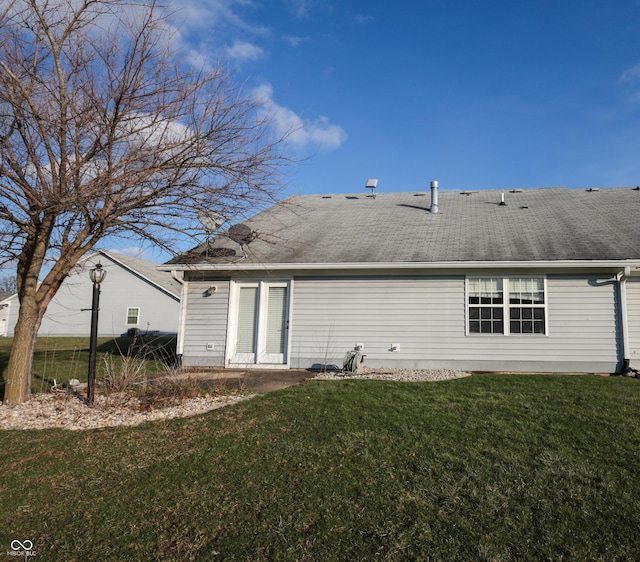 rear view of property featuring a lawn