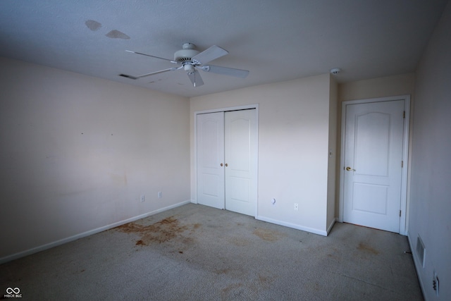 unfurnished bedroom with light carpet, a closet, and ceiling fan