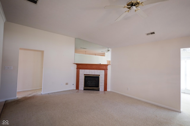 unfurnished living room featuring ceiling fan, a fireplace, and light carpet