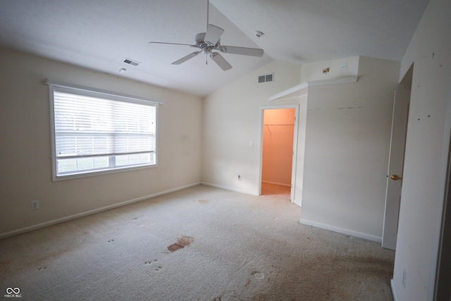 carpeted empty room with vaulted ceiling and ceiling fan