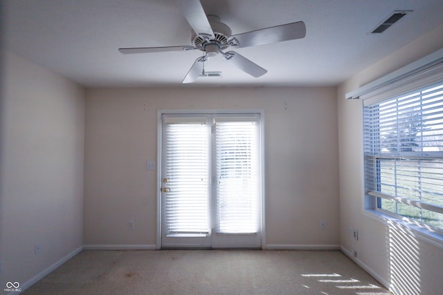 empty room featuring ceiling fan and light carpet