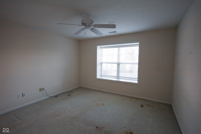 carpeted spare room featuring ceiling fan